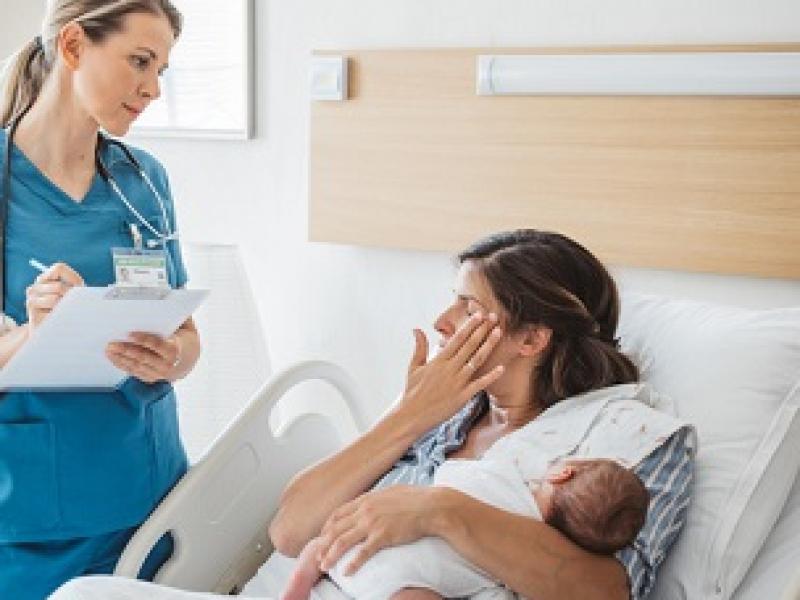 New mom  holding baby and talking to Doctor 