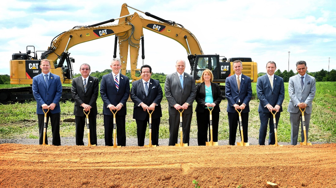 Group of Inspira staff standing in front of construction equipment at site of new medical center in Mullica Hill. 