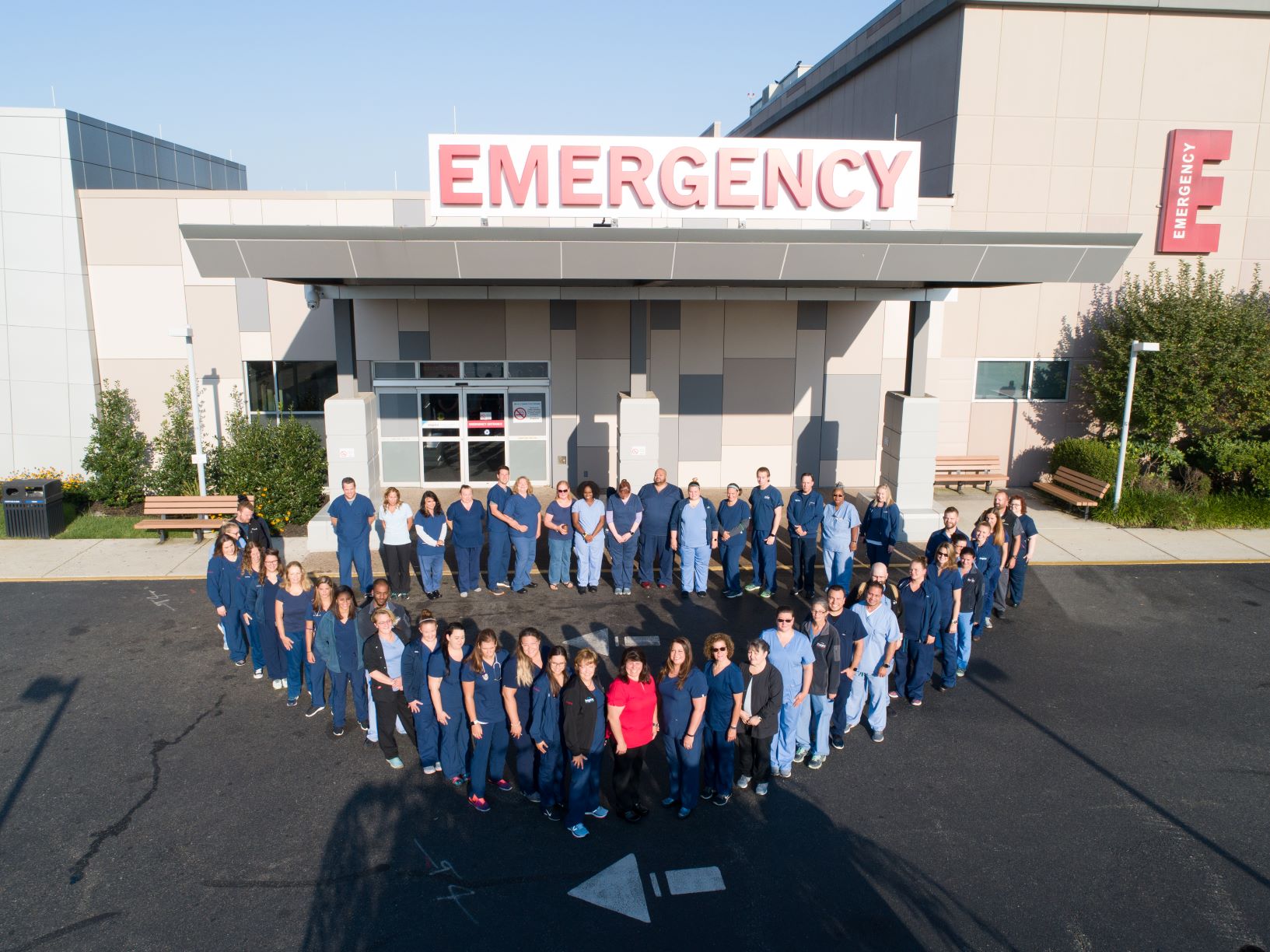 A group of health care workers standing in the shape of a heart