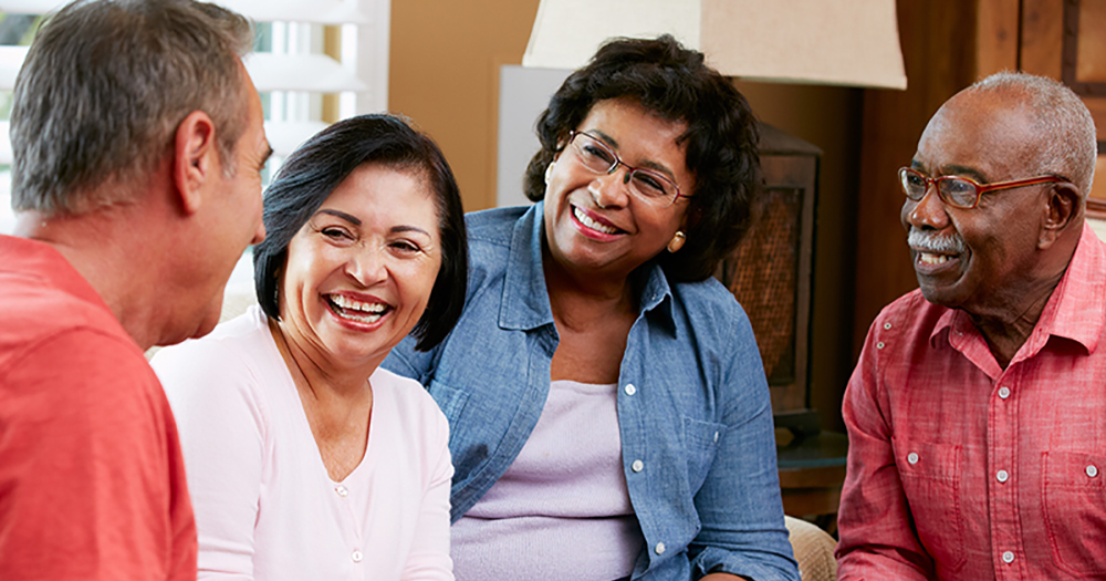 A group of adults talking together and smiling