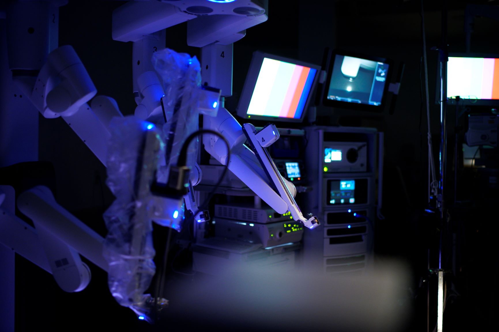 Robotic surgery equipment lit up in a dark room
