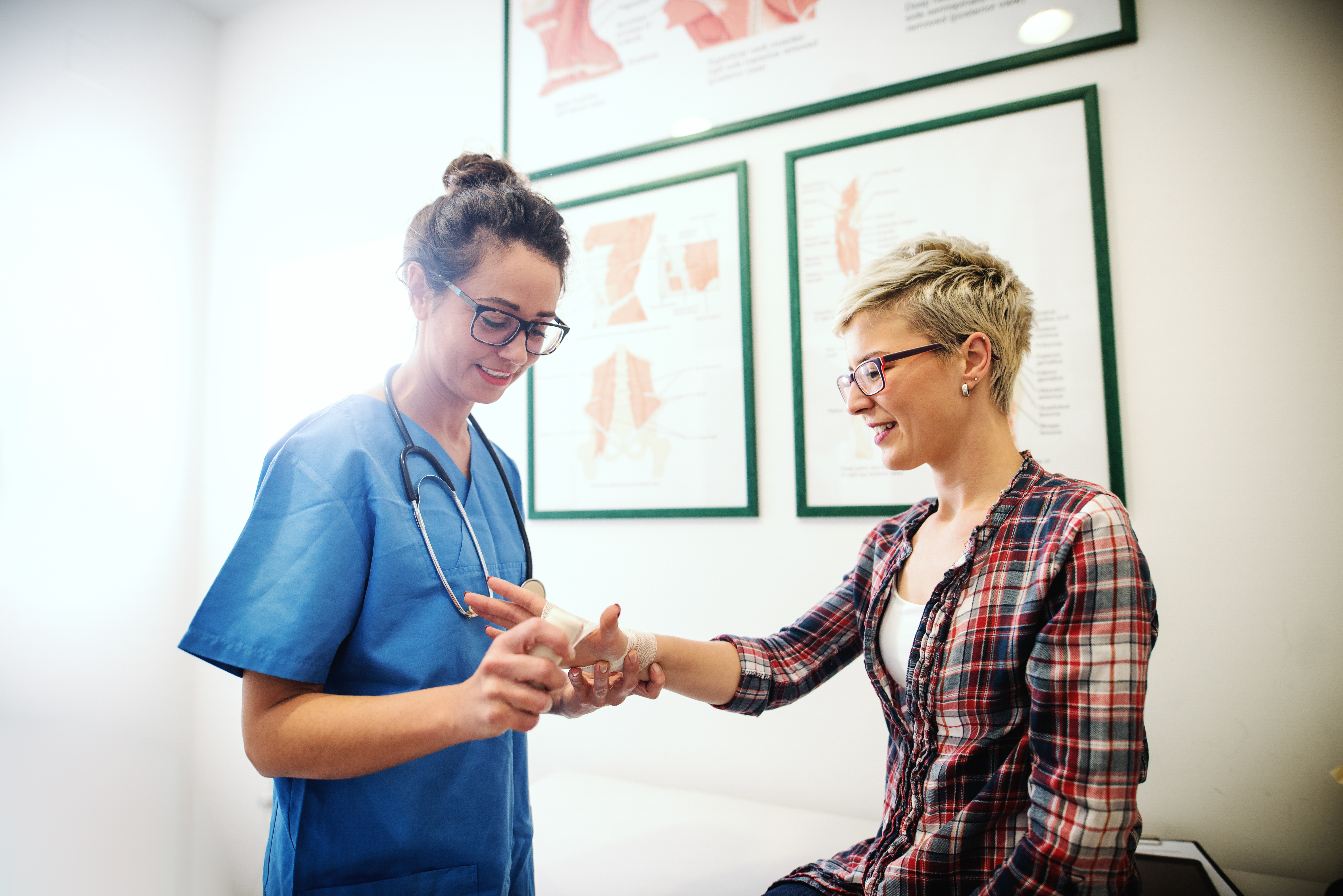 A patient with a wrist splint being examined by a provider