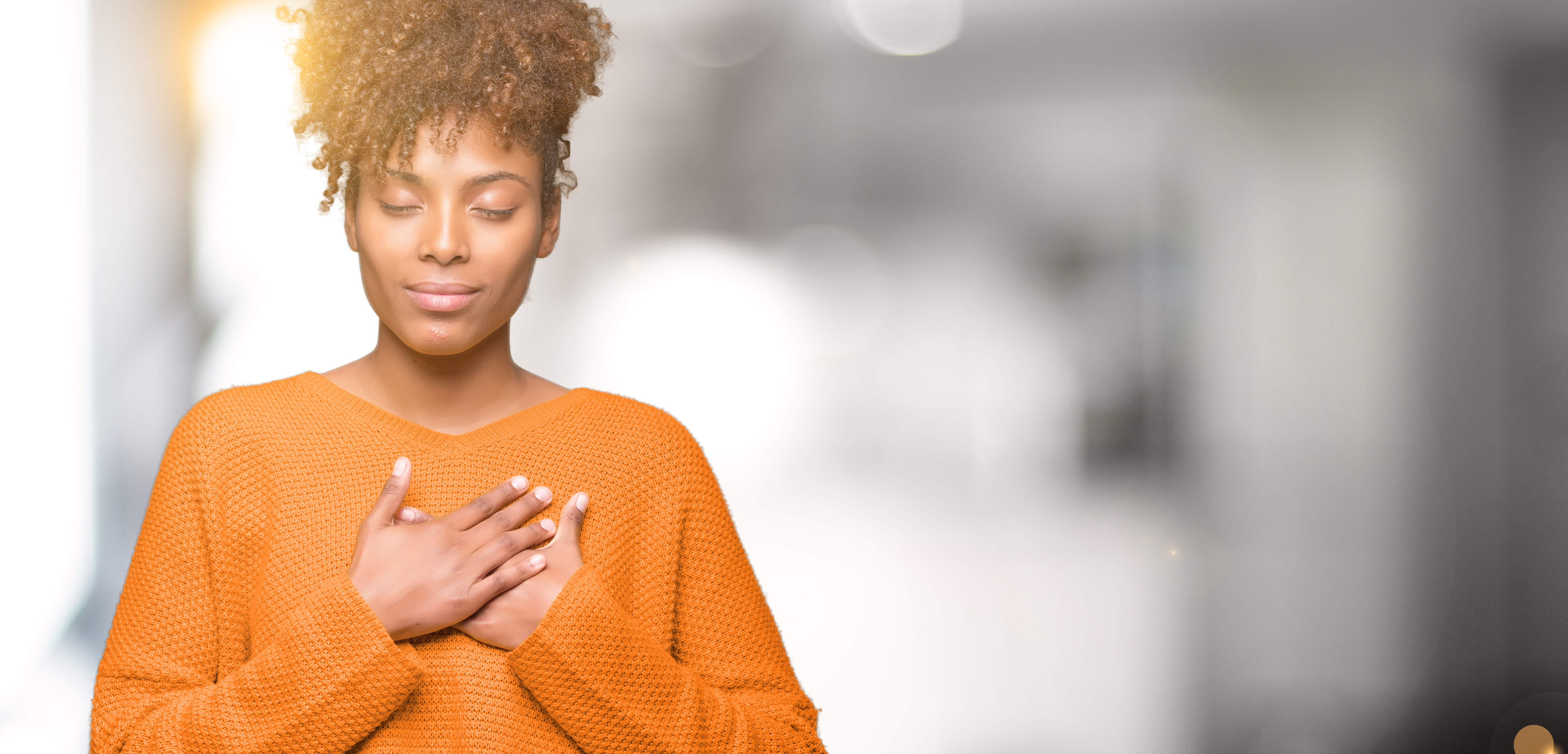 A woman holding her hands to her heart