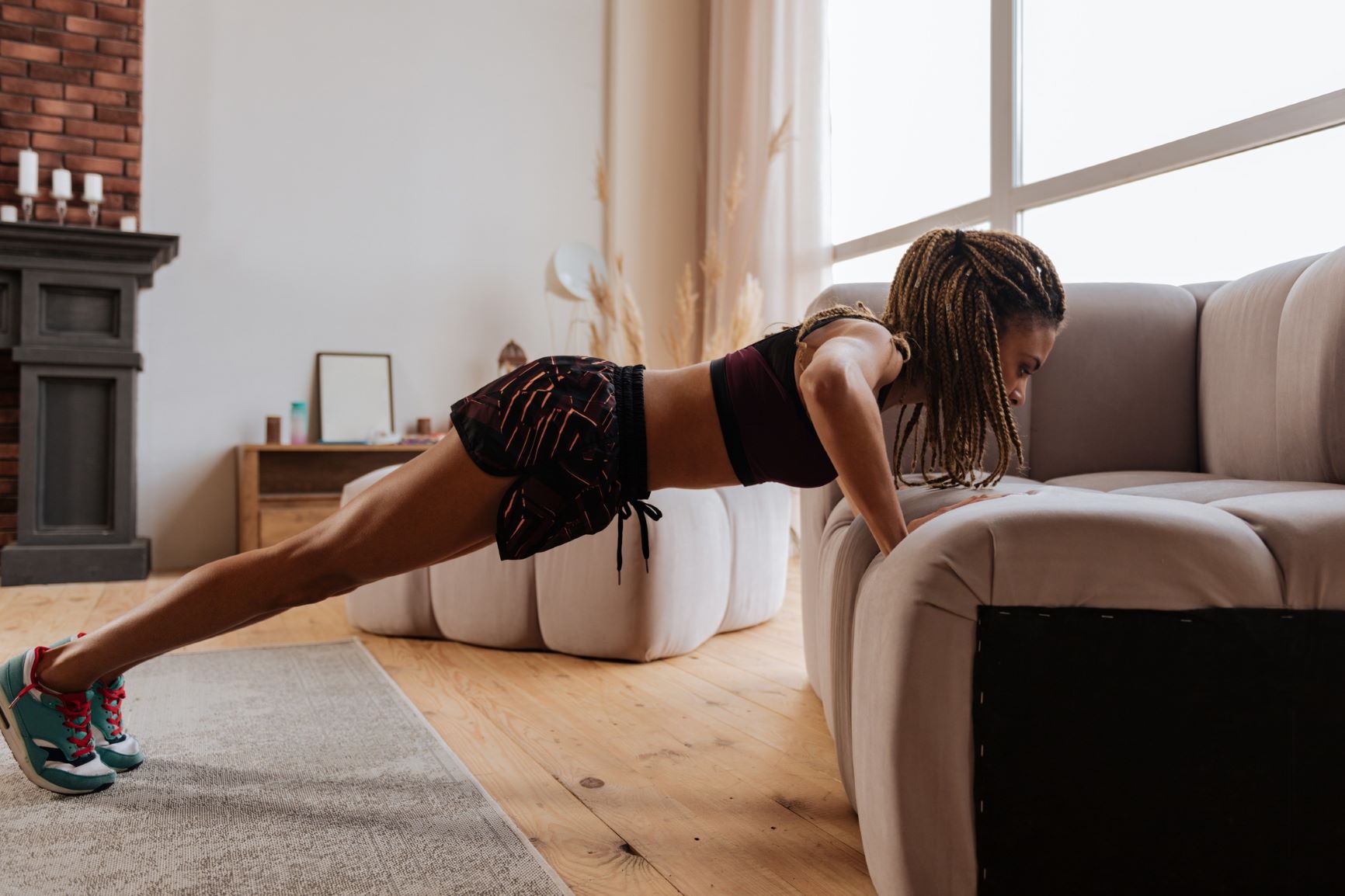 Woman doing a push-up in her home on her couch