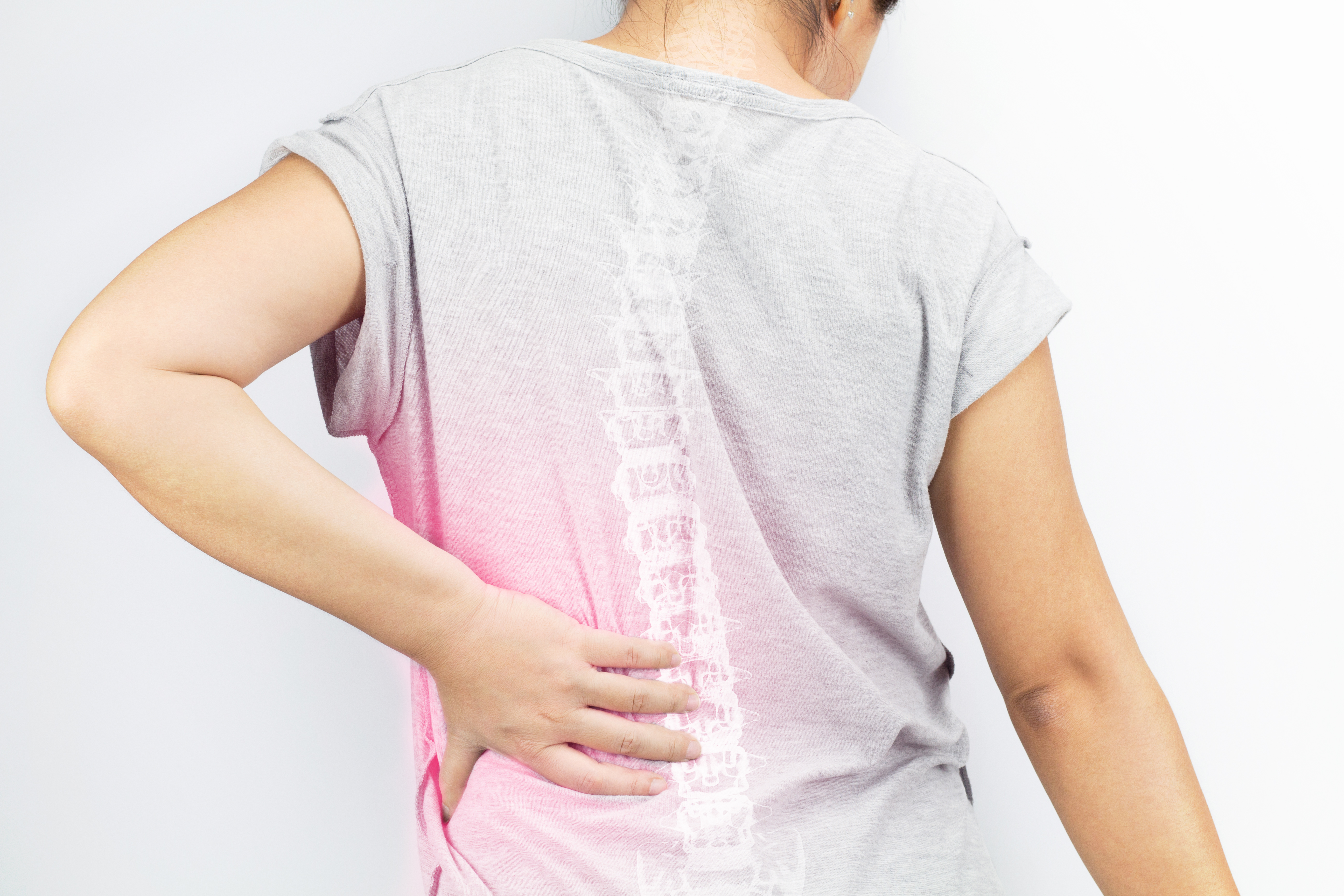 A person touching their back with an illustration of a spine overlaid on their t-shirt