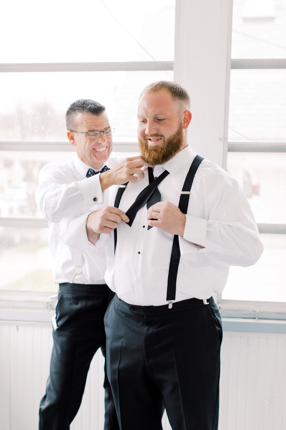 A man helping his son get ready for his wedding