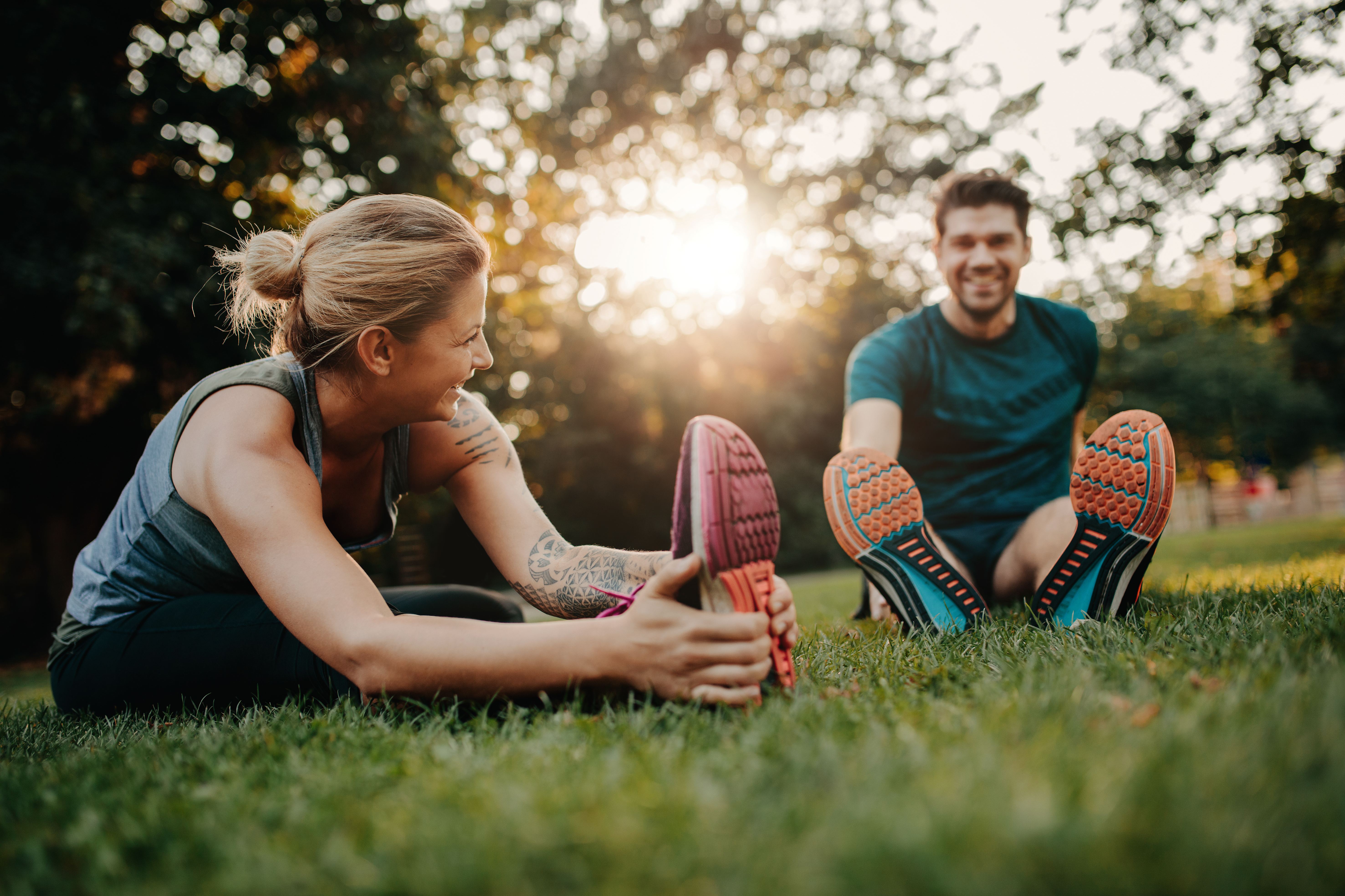 man and female stretching in the grass