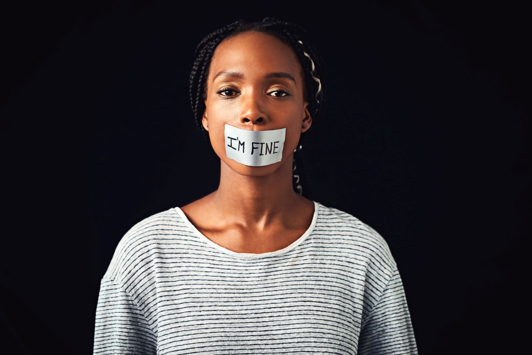 Woman with tape over her mouth which has "I'm fine" written on it