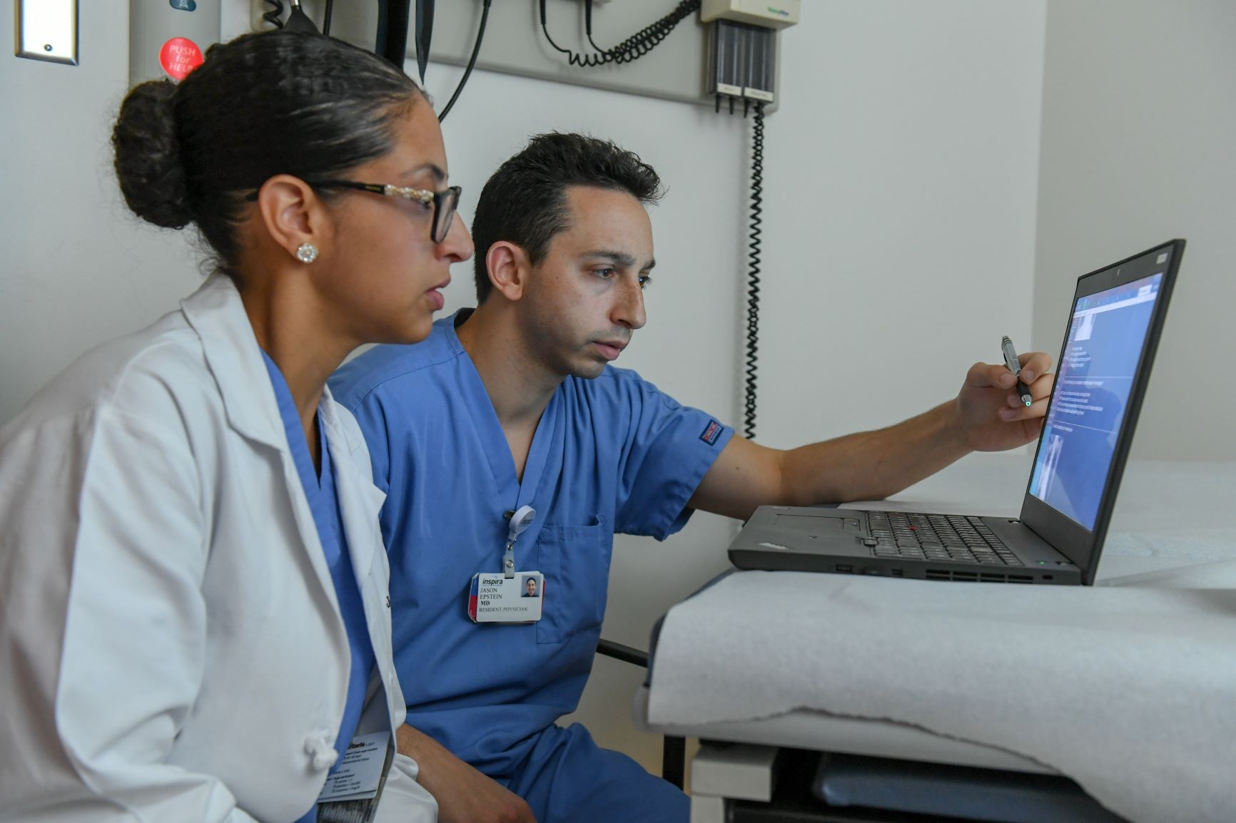 Physician and medical student studying a computer screen