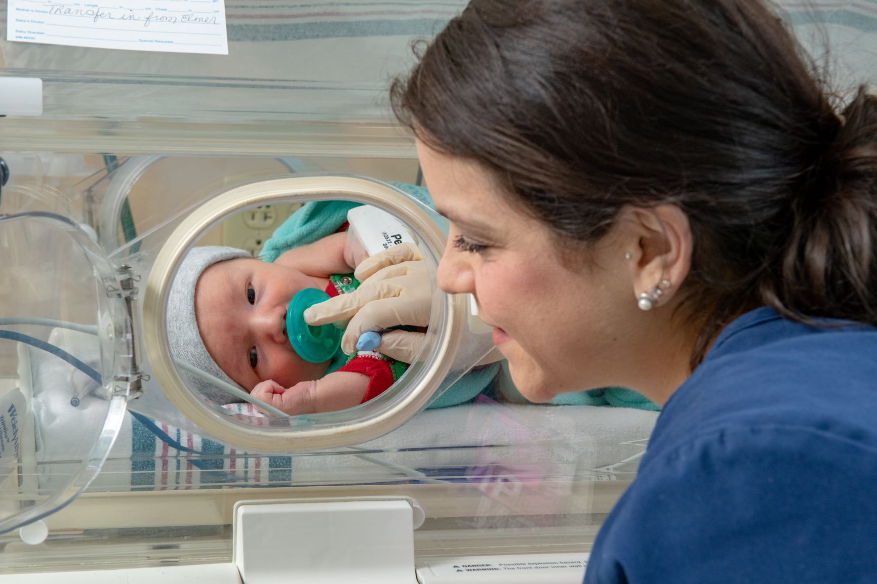 nicu baby in incubator with nurse