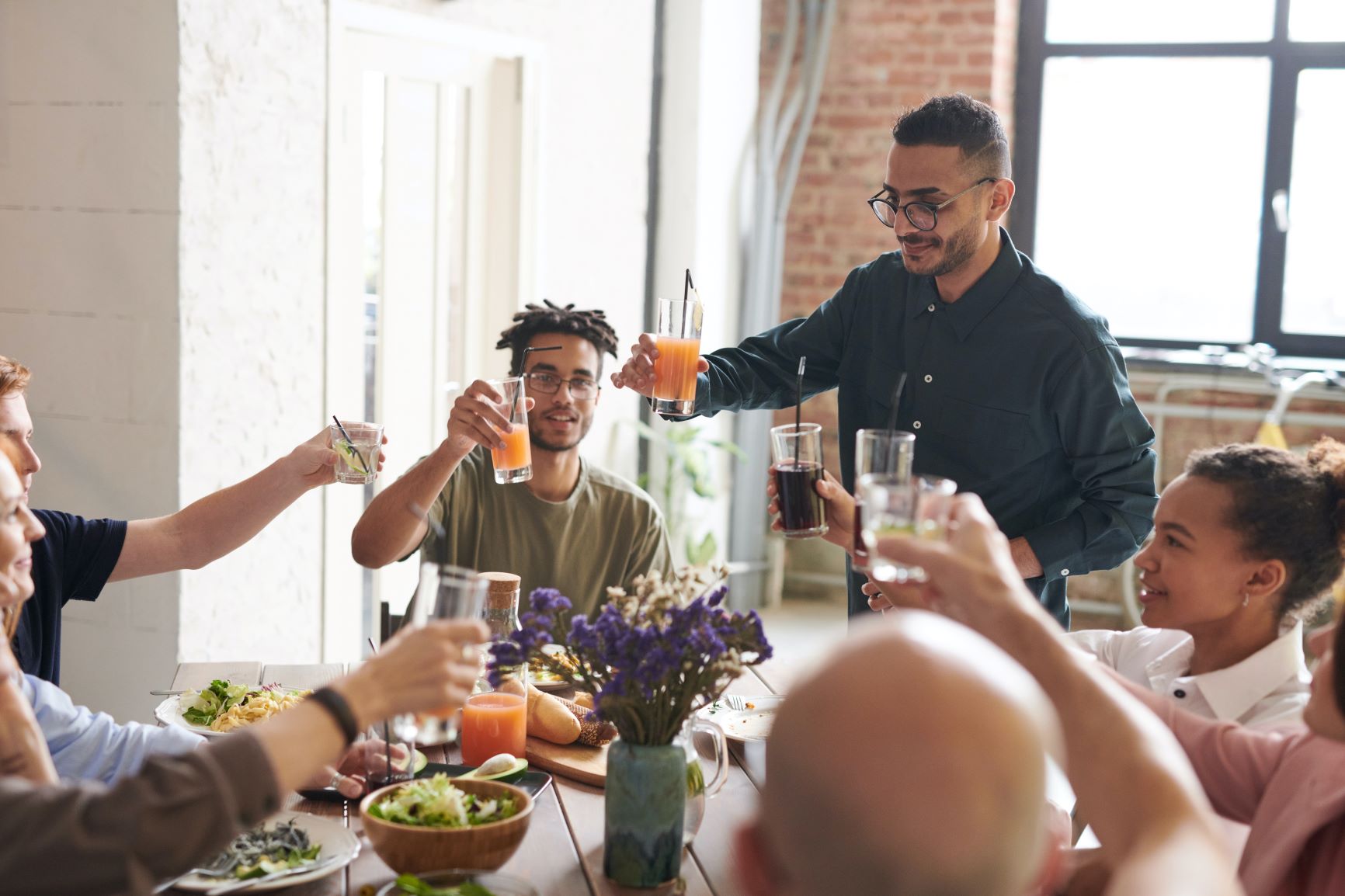 Group of people cheering with drinks around a table