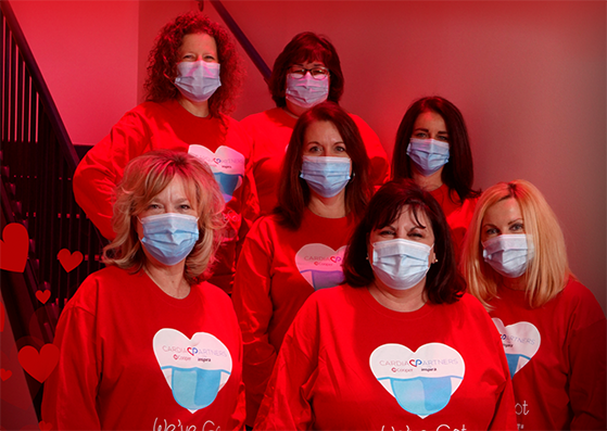 Group of people wearing red cardiac partners shirts while wearing face masks