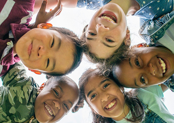 group of smiling children with their heads together