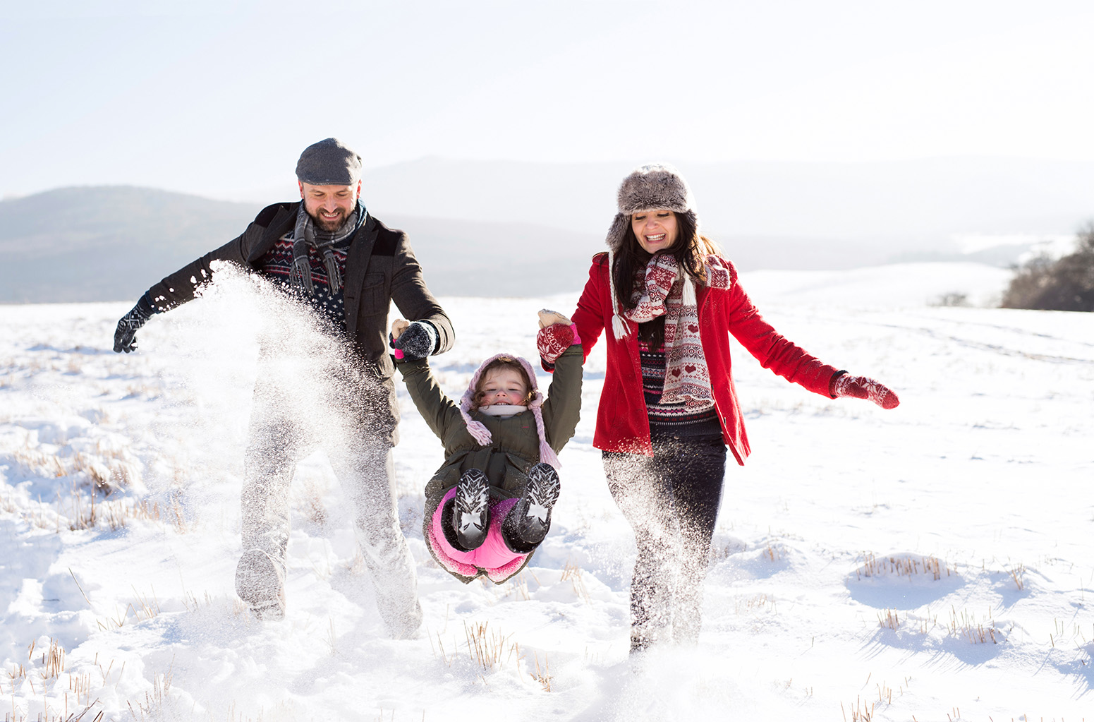 family with young child playing in the snow