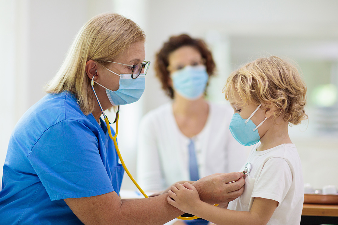 Pediatrician doctor examining sick child in face mask. Ill boy in health clinic for test and screening. Kids home treatment of virus. Coronavirus pandemic. Covid-19 outbreak. Patient coughing.