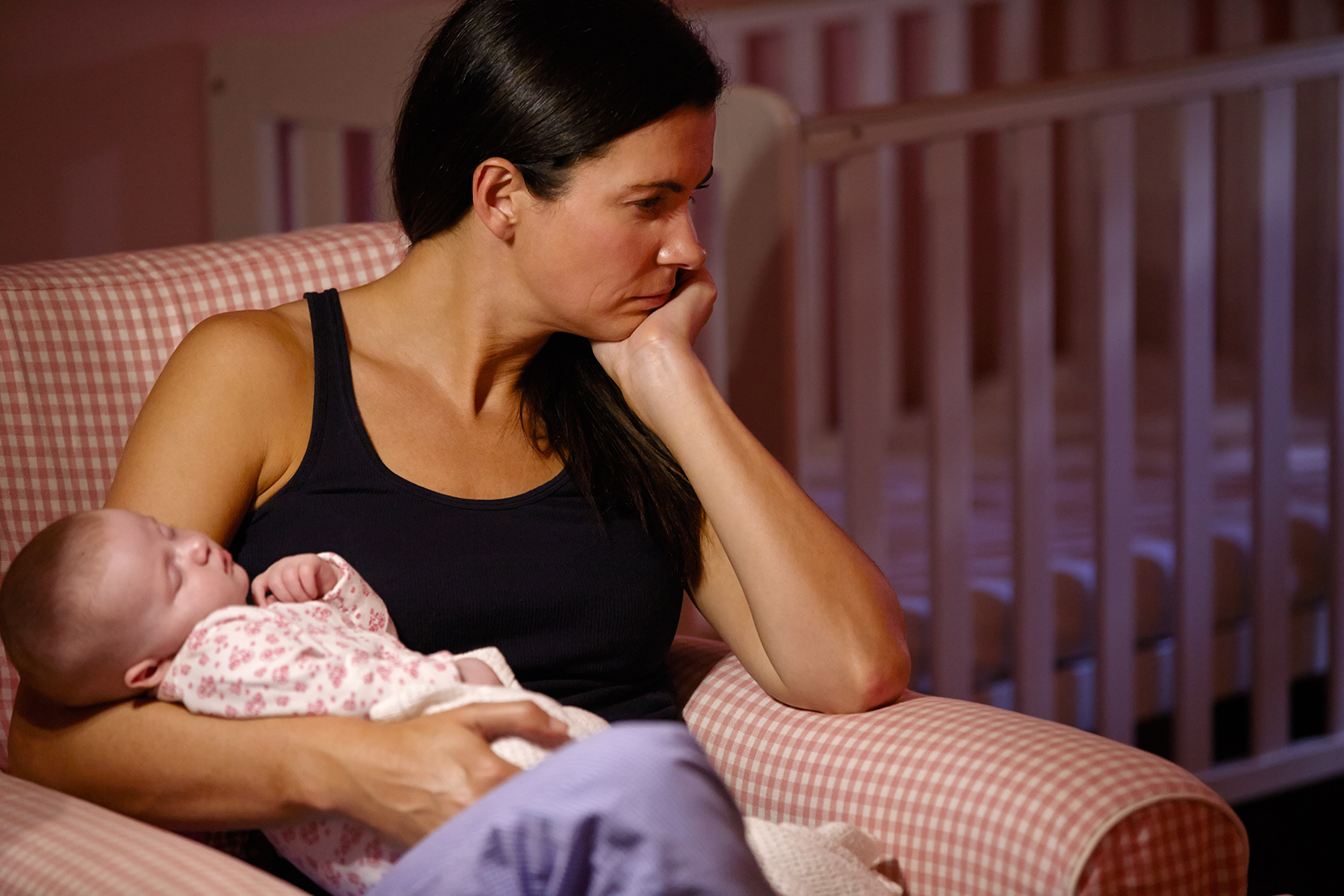 Mother holding baby, sad