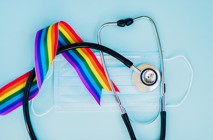 Stethoscope and LGBT rainbow ribbon pride symbol. Blue background