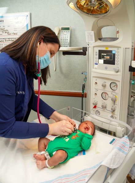 Waverly Lutz, CNM listening to a new born's heart
