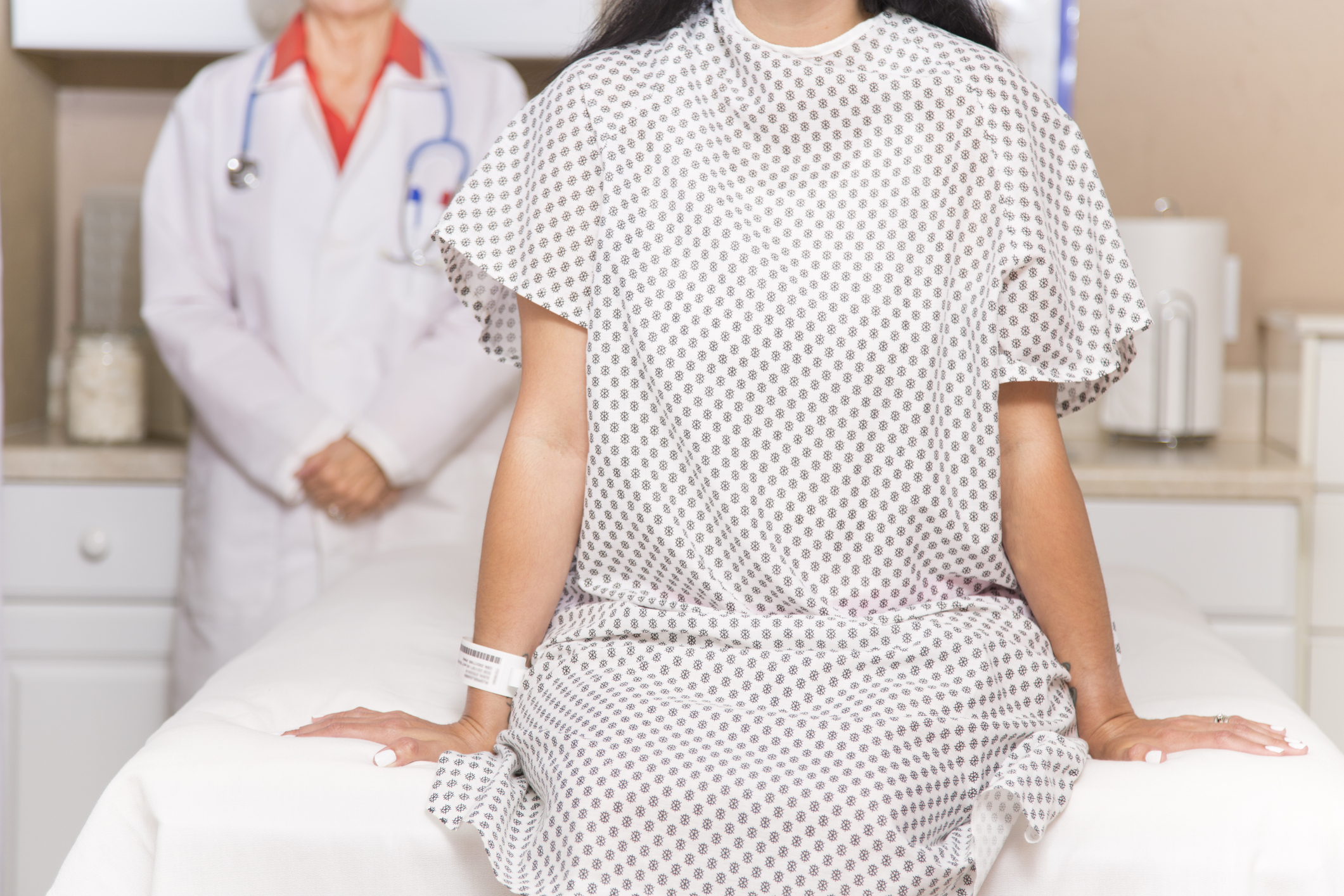 Woman wearing hospital gown prepares for medical procedure