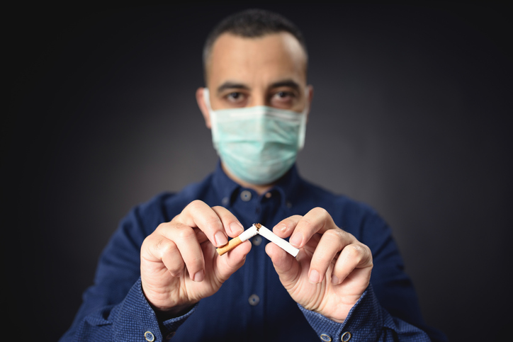 Man in mask breaking cigarette