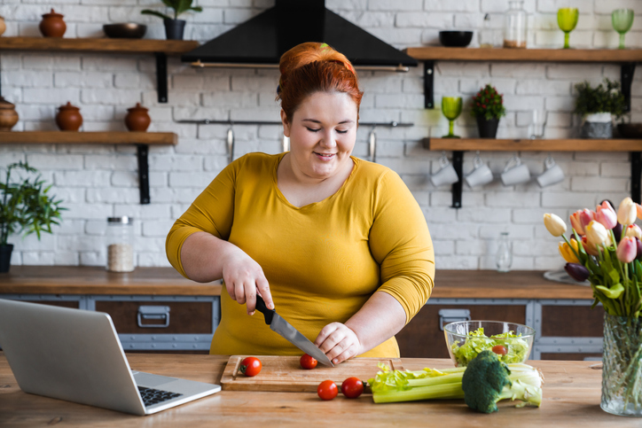Plus size , caucasian woman learning to make salad and healthy food from social media,Social distancing, stay at home concept stock photo