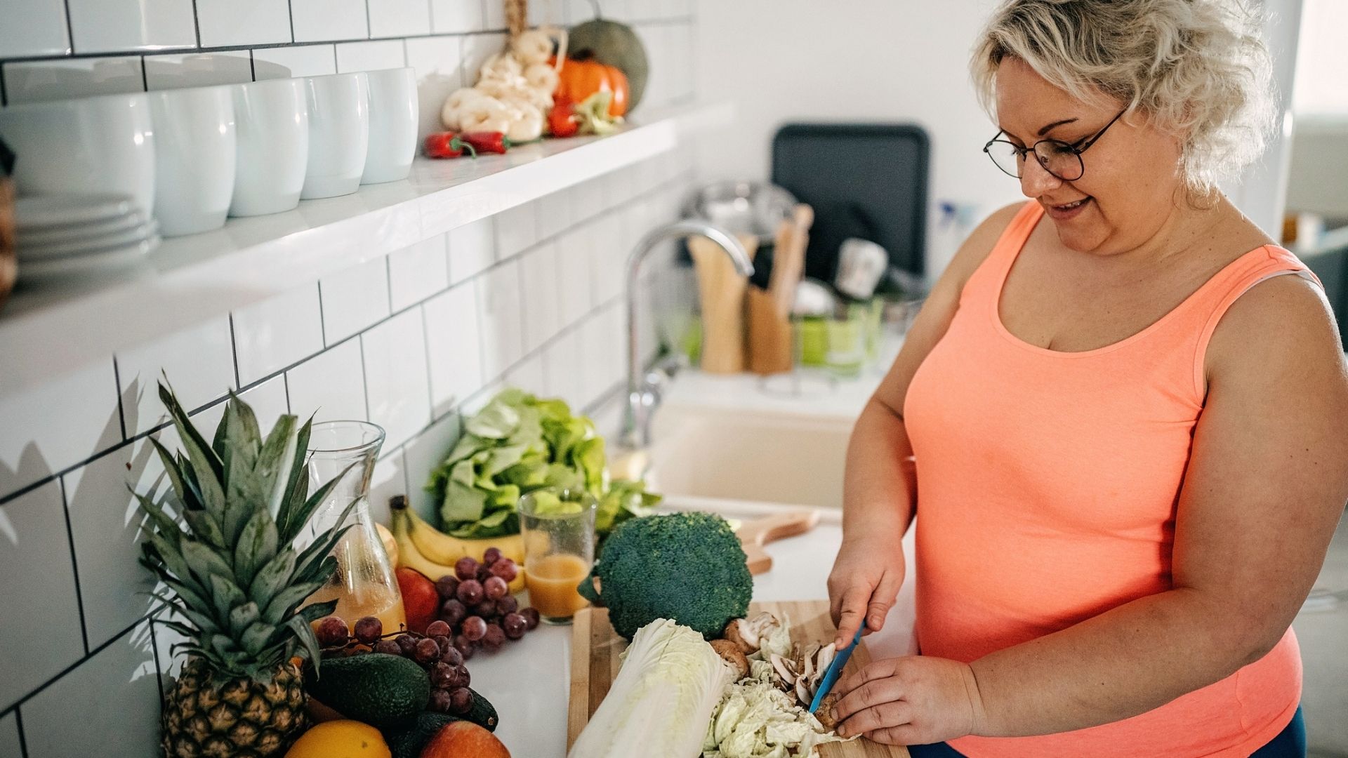 Heavy set woman chopping fruits and vegetables