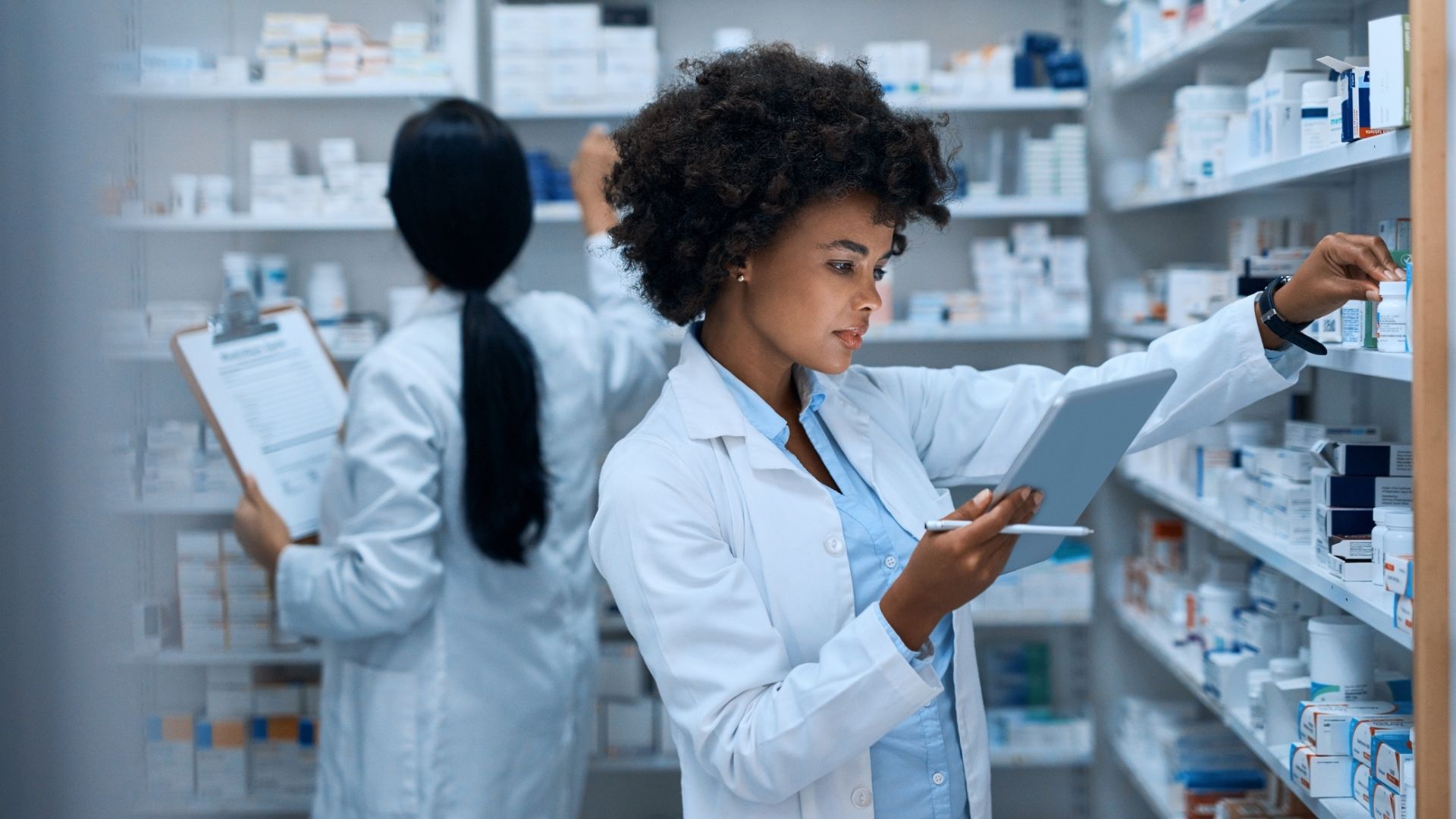 Female pharmacist grabbing medication from stock room
