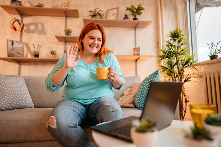 Woman drinking coffee with friends on video call