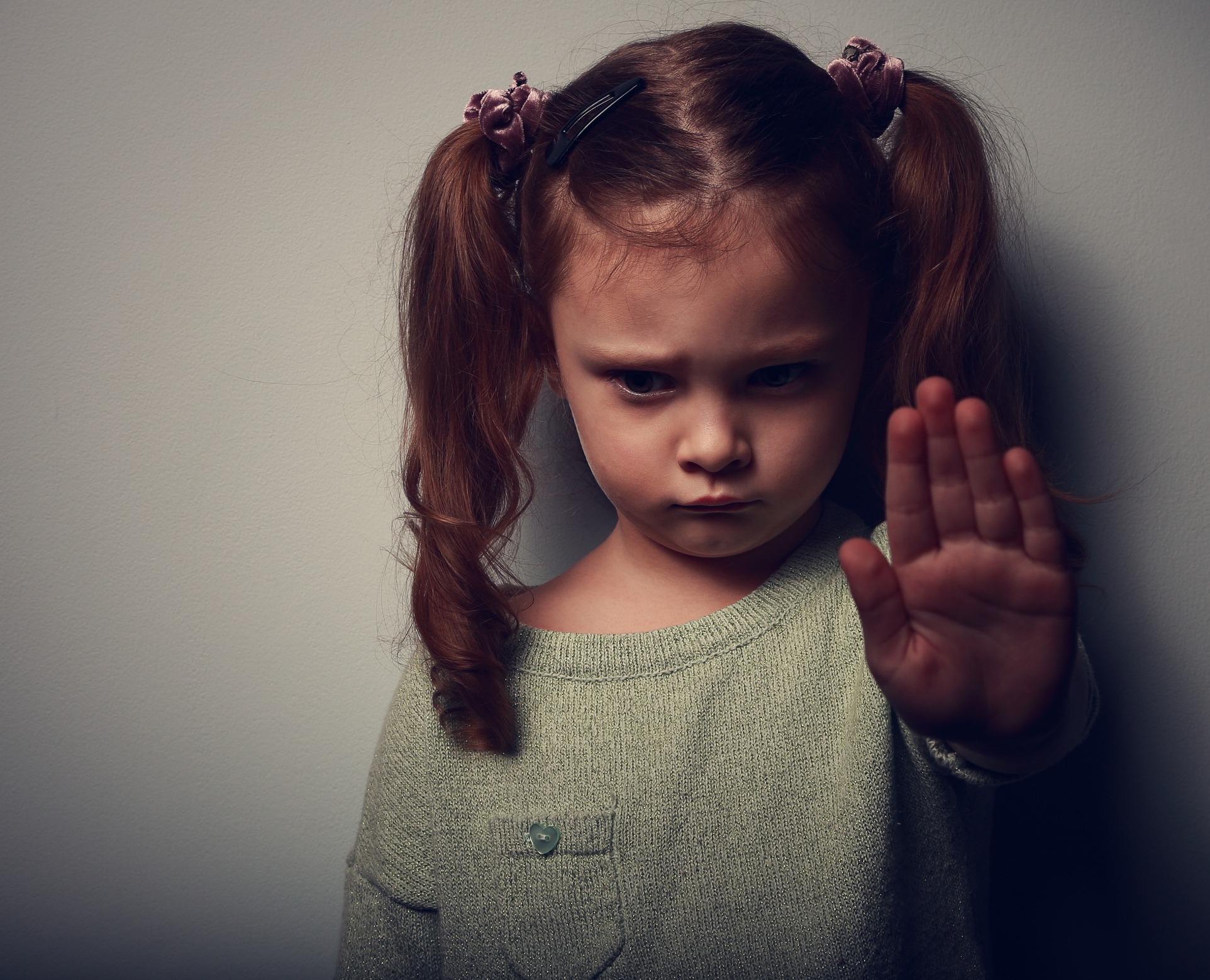 Young child with her hand up