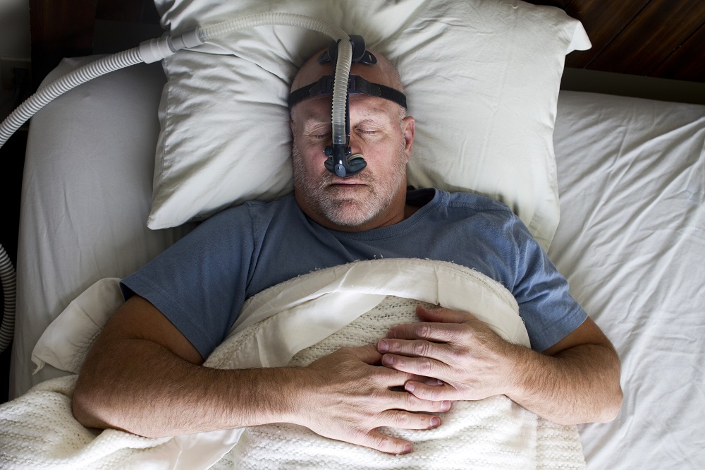 Man with CPAP machine sleeping