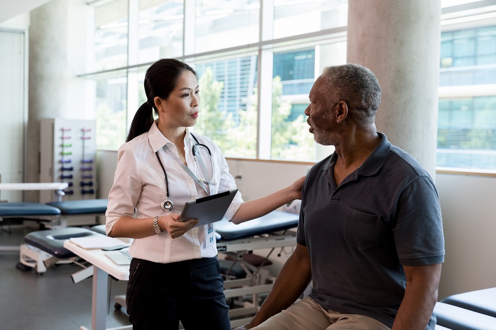 Women Physiatrists speaking with a male patient