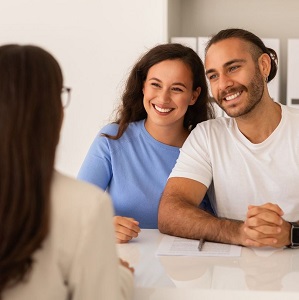 Young Couple Holding Hands and Talking to Female Doctor