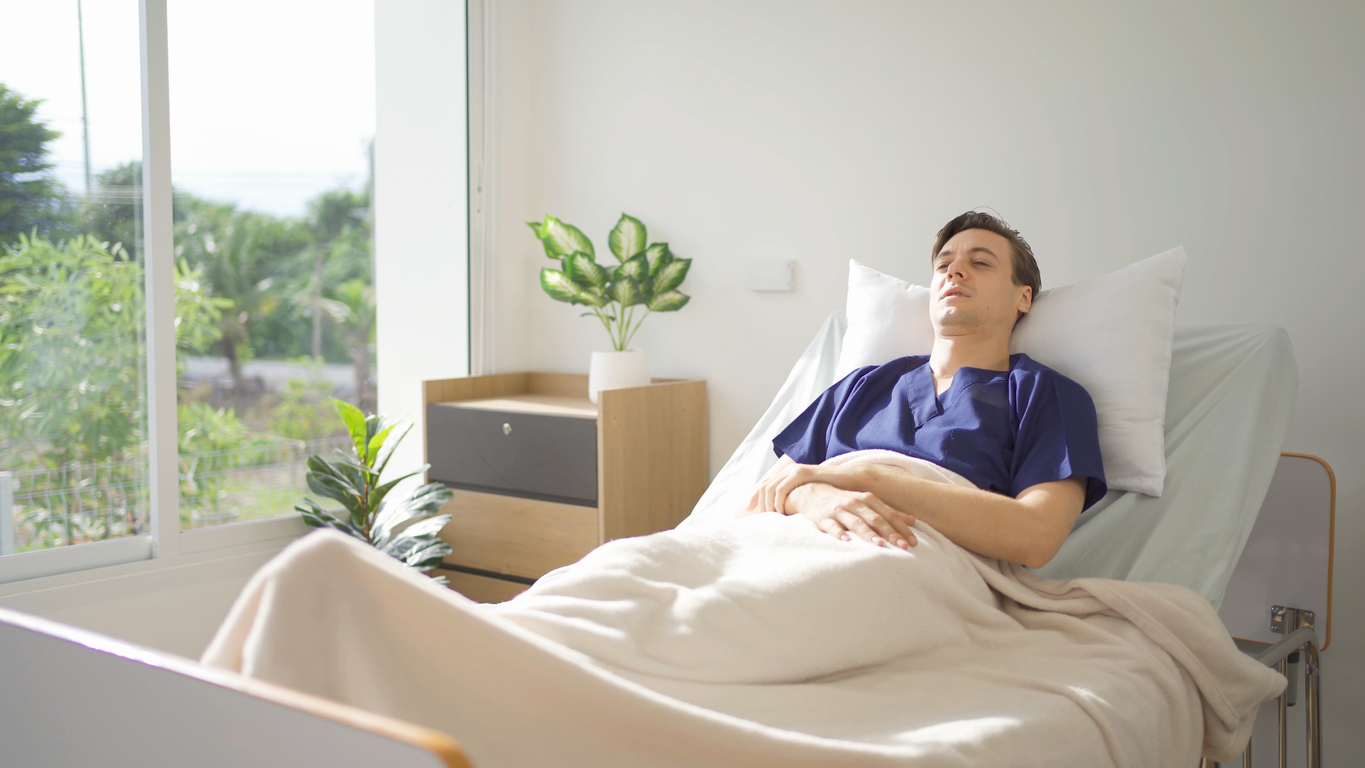 Young man lying in hospital room