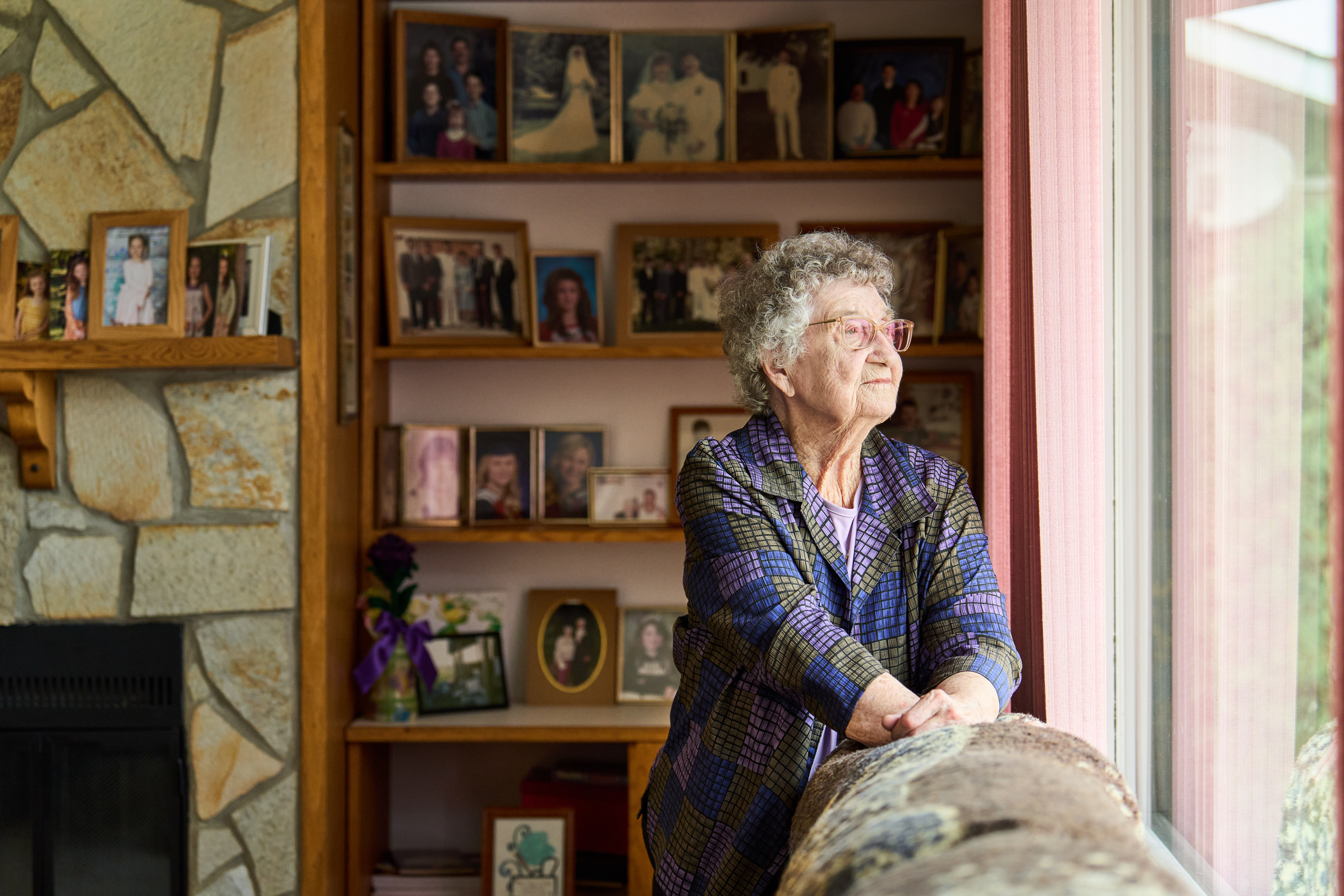 Older woman in social isolation looking out of her window