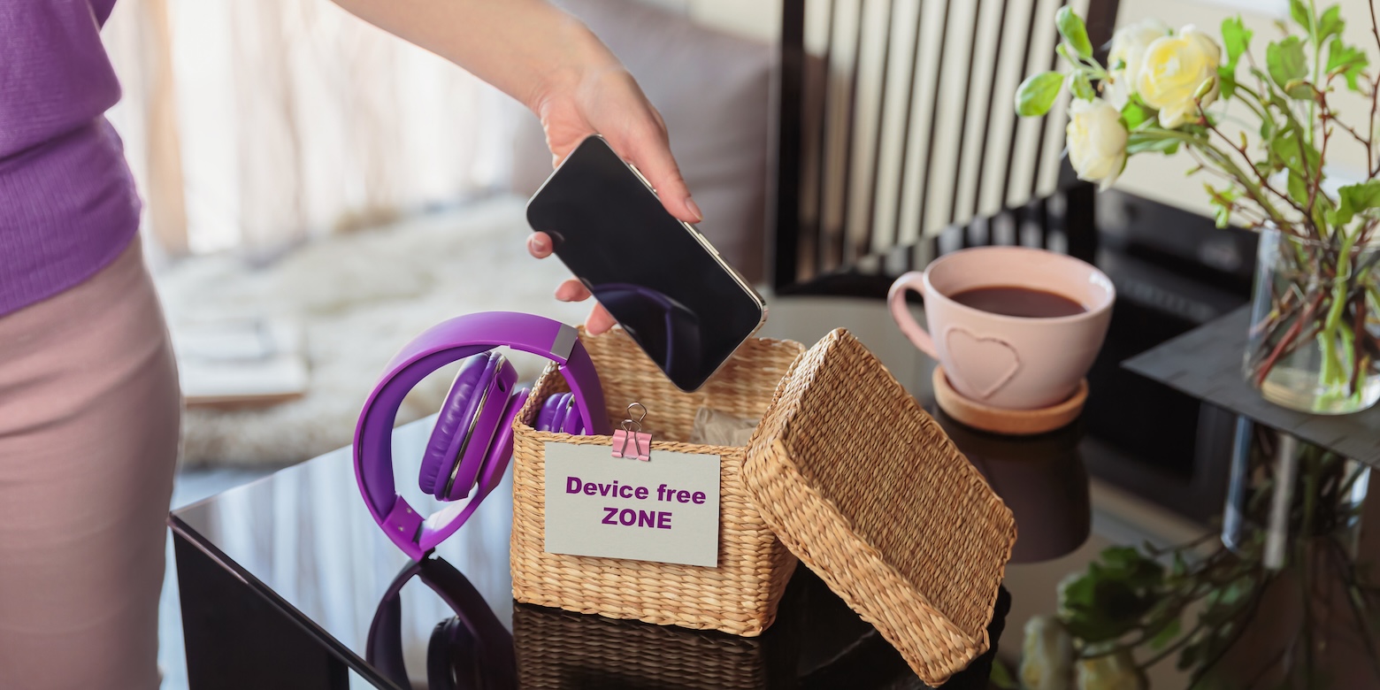 woman's hand putting phone in basket for digital detox
