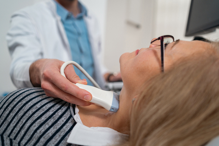 Doctor checking patient's thyroid gland