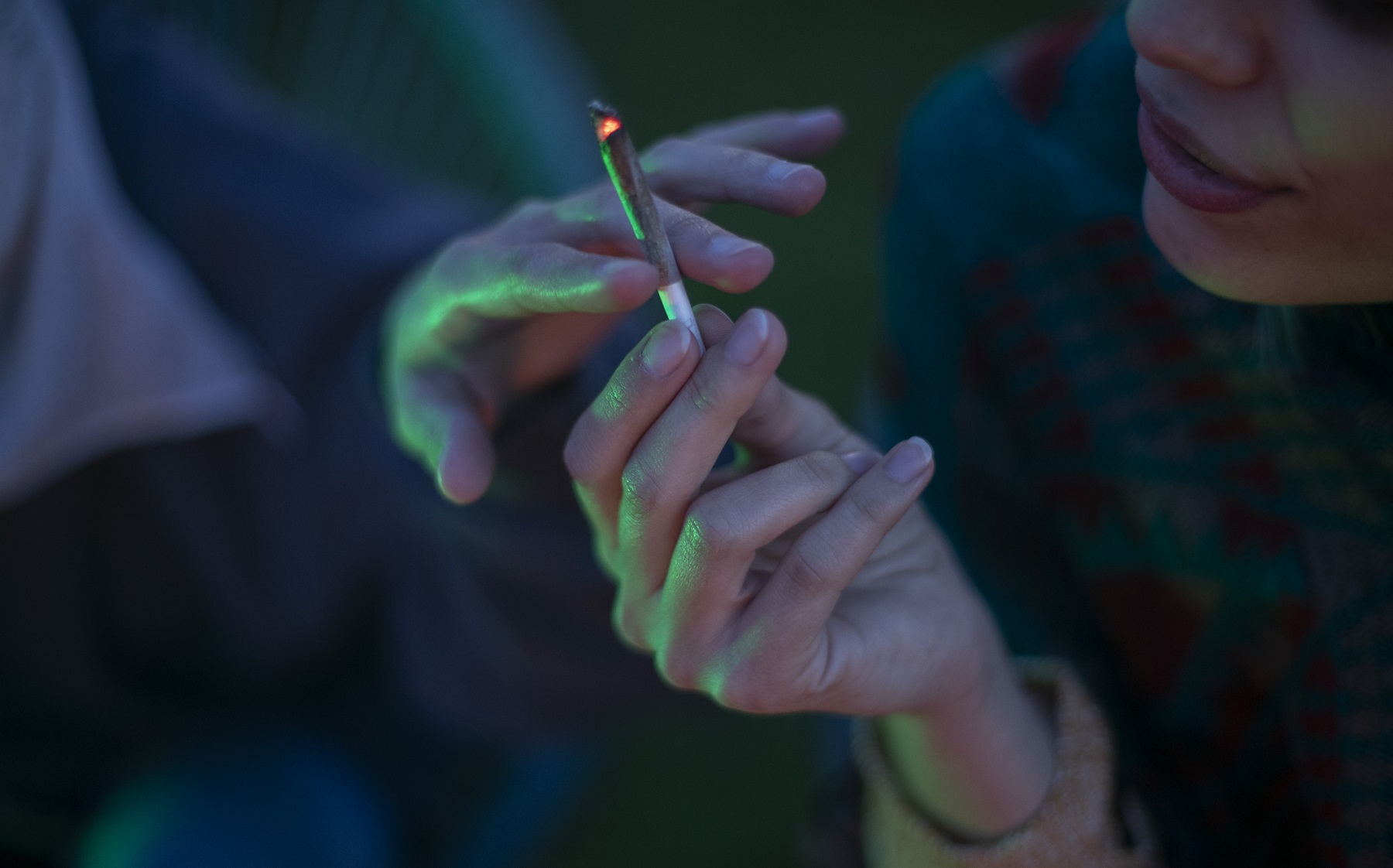 two adults passing cigarette