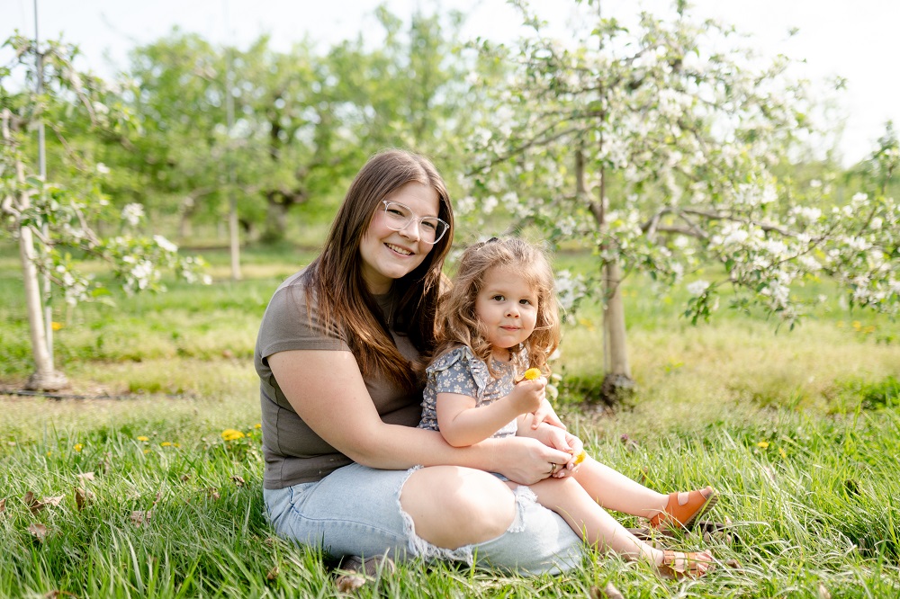 Mom and daughter sitting in apple farm