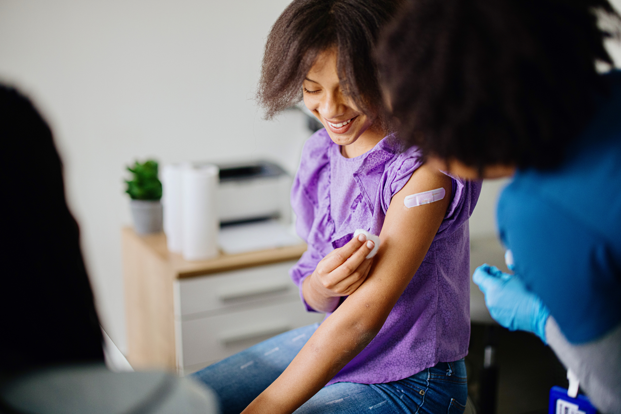 Young girl smiling after taking vaccine shot
