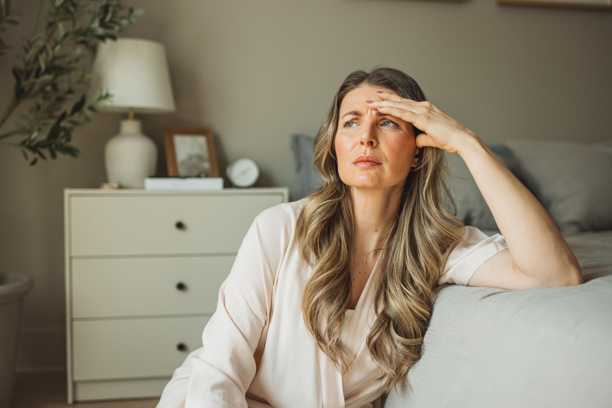 mid age woman sitting worried bedside