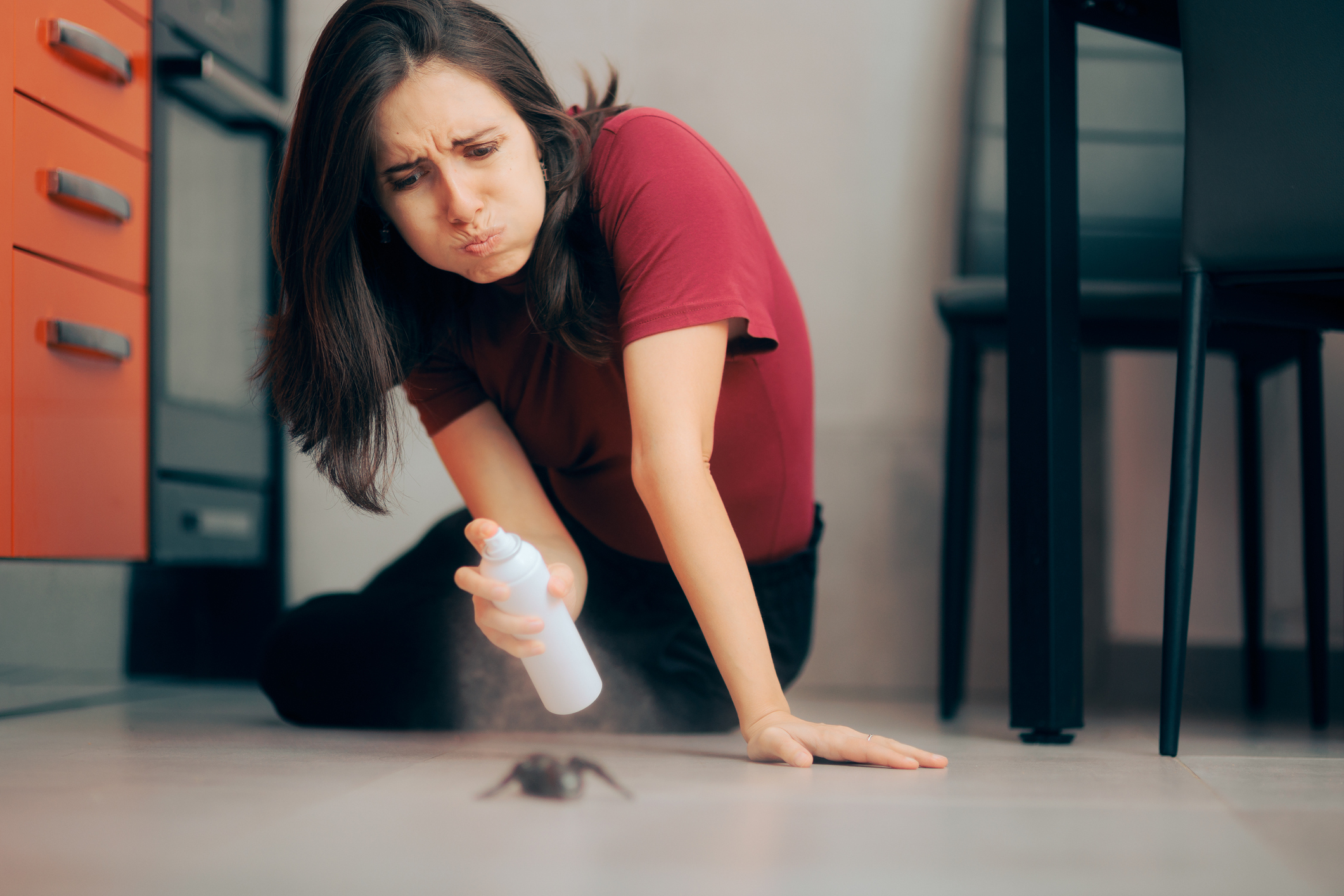 woman spraying disinfectant on a bug