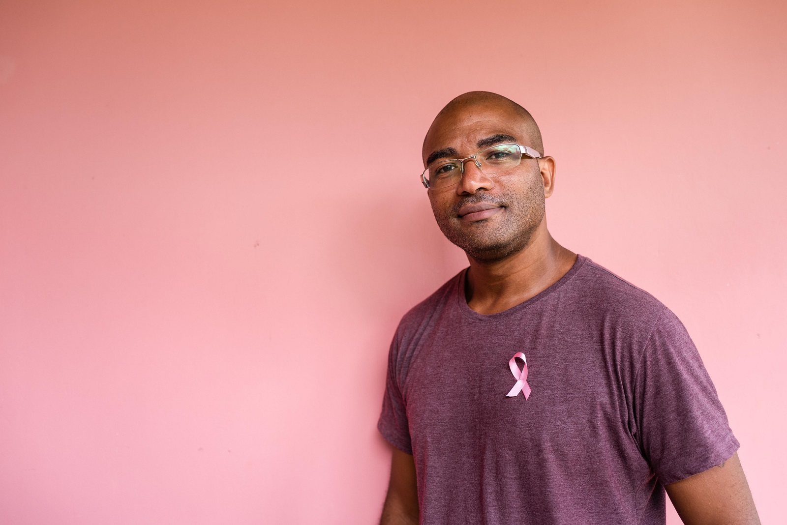 Male with pink breast cancer awareness ribbons on the man’s shirt