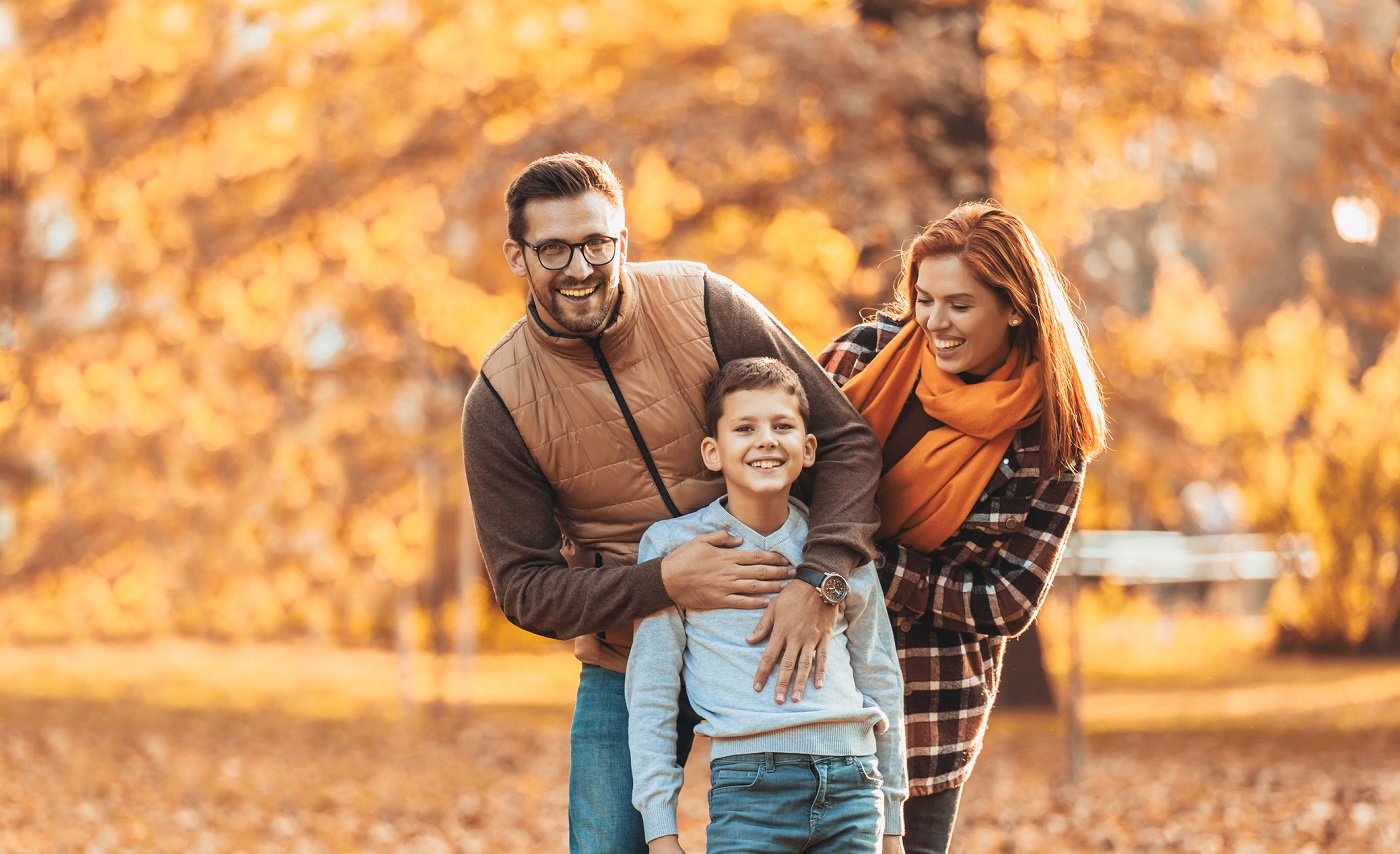 Happy family having fun with leaves on an autumn day