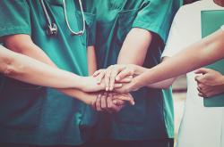 group of medical professionals holding hands