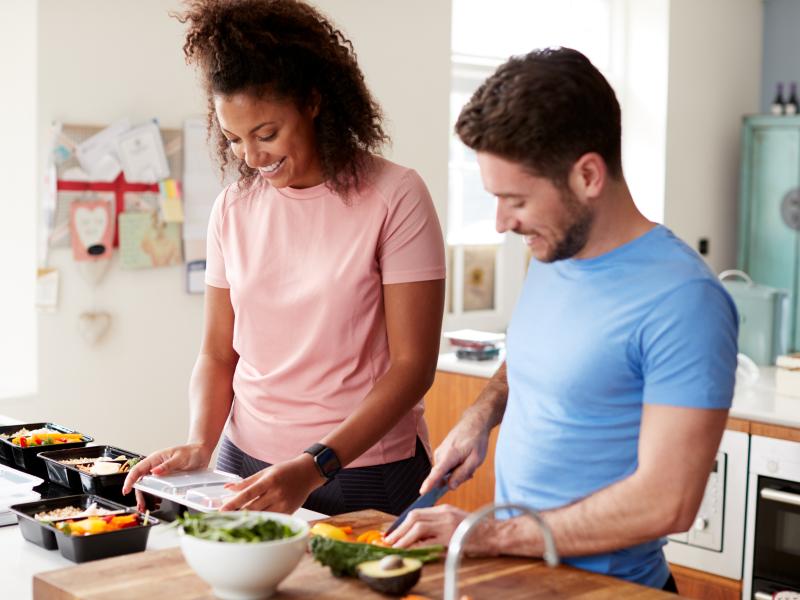 smiling man and woman doing meal prep
