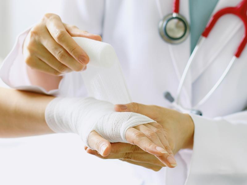 Doctor wrapping bandage around wrist