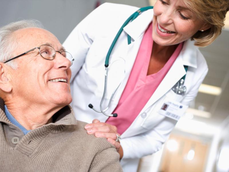 older man smiling up at a female physician