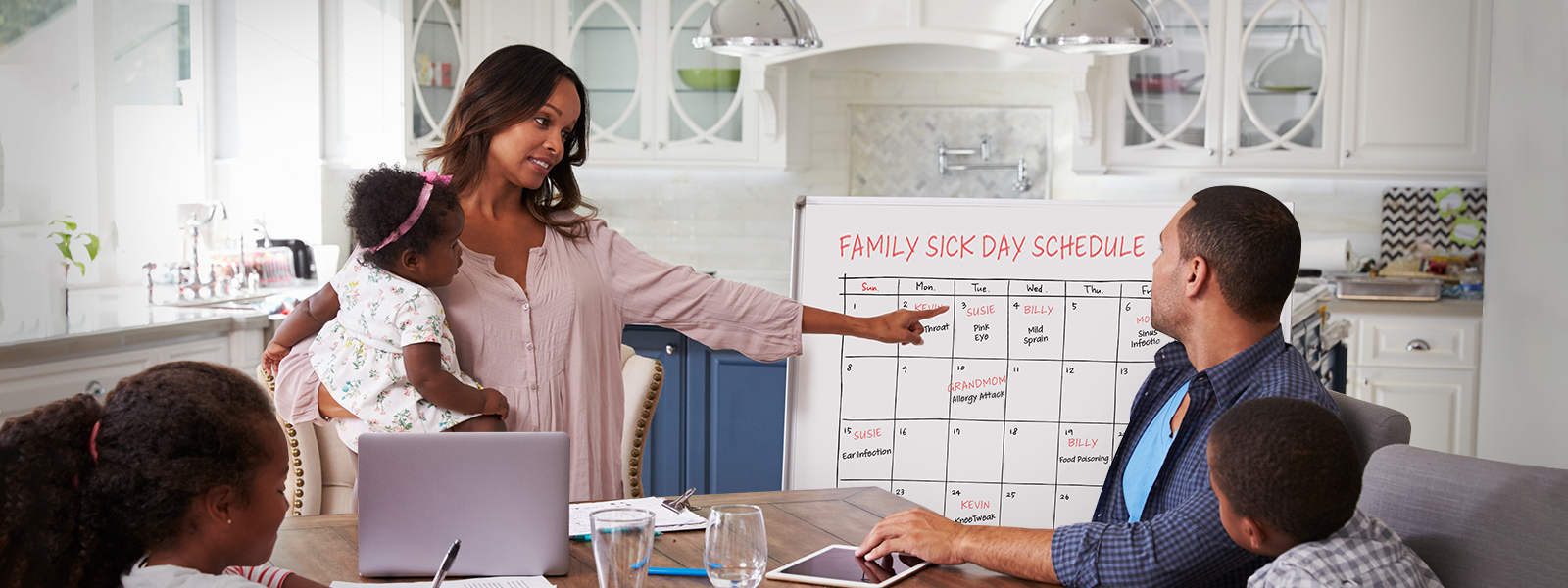 Family at table reviewing family sick schedule