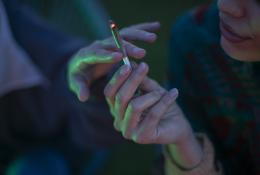 two adults passing cigarette