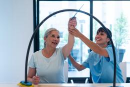 Therapist doing movement therapy with elderly woman patient